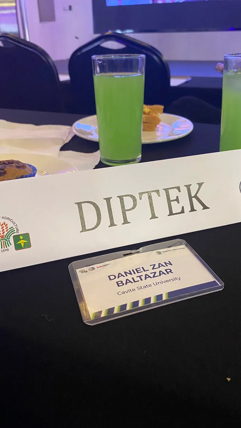DIPTEK table nameplate and Daniel's Cavite State University delegate ID