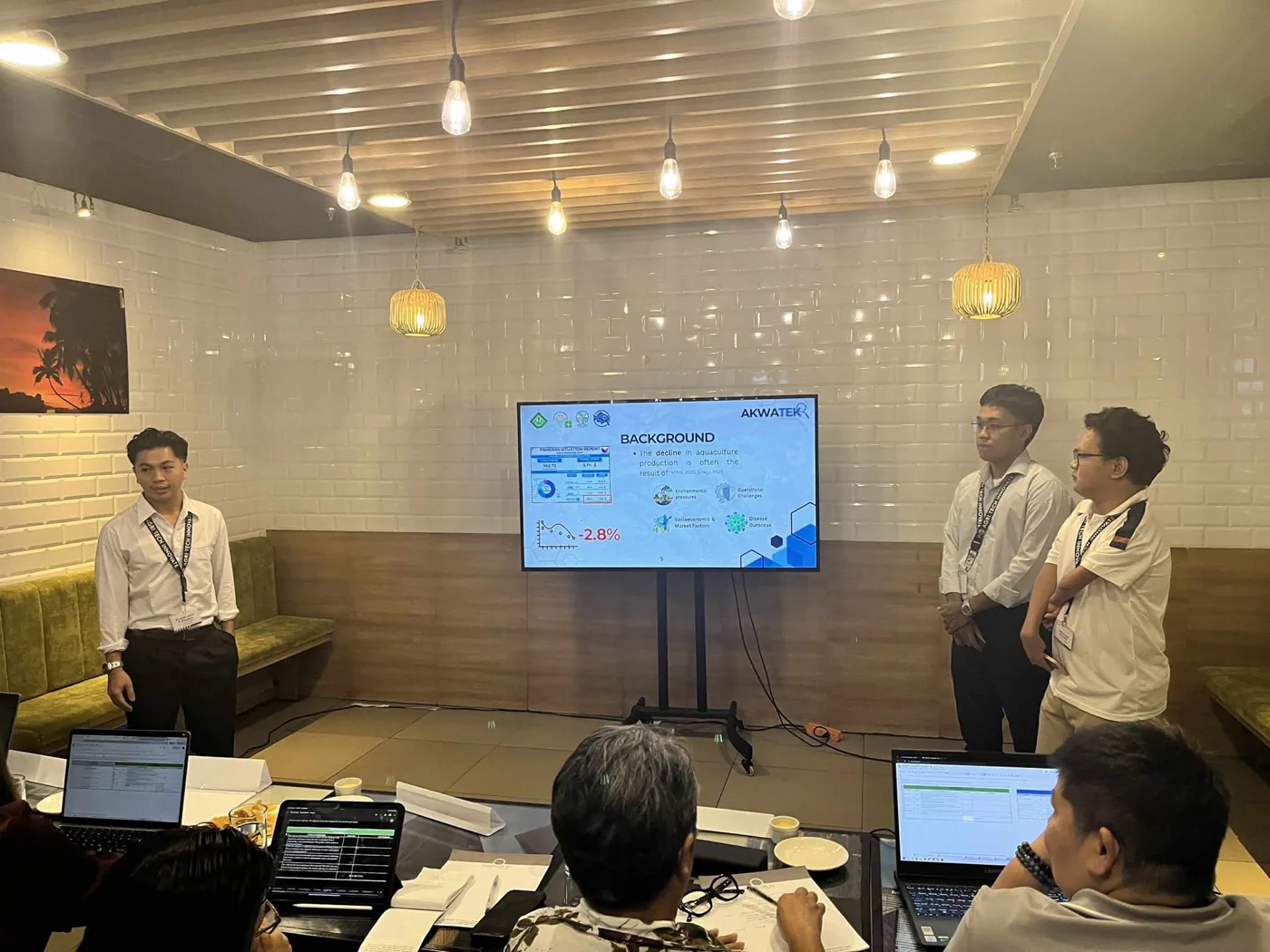 Three teammates pitching to mentors in front of a screen during the bootcamp